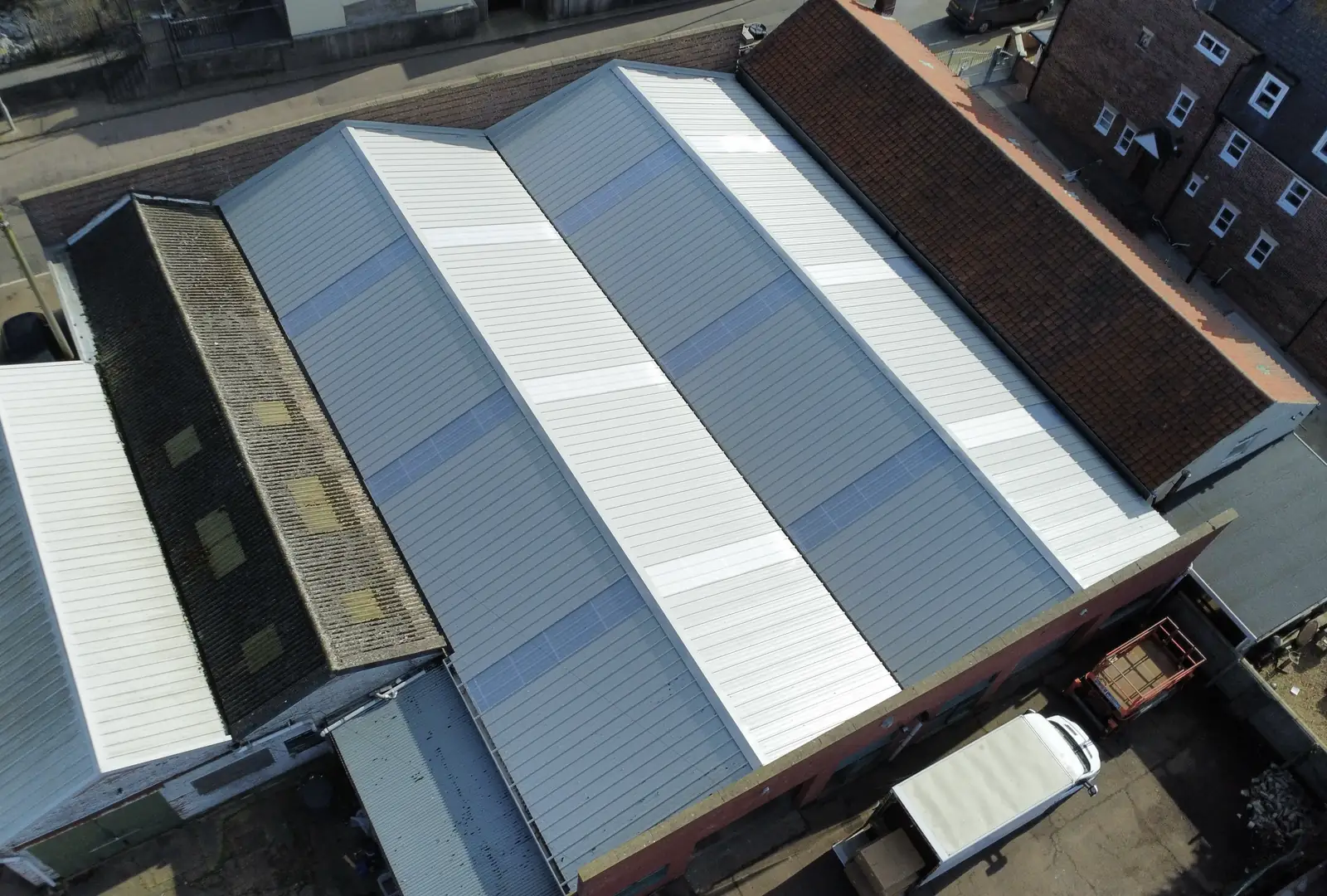 Aerial view of a commercial building in East Anglia with a completed grey metal roof by Over The Ridge Roofing