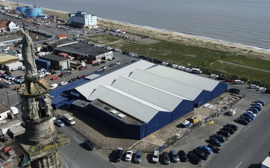 Large commercial building reinstated with a new white metal roof and navy cladding